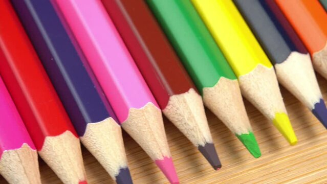 Colorful pencils rotate as a background. Rainbow pencils for drawing. Assortment of colored pencils. Back to school concept