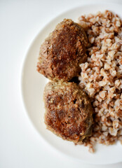 Buckwheat porridge with meat patty. Delicious meat breakfast on a plate.