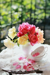 Englische Rosen in einer Vase mit Tassen