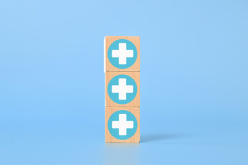 Plus icon on wooden blocks for medical and health care concept, Access to welfare health, People with health care, Health insurance, Family life insurance, Medical care insurance