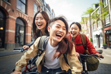 Happy group of young Japanese people with backpack riding a bike in Amsterdam. Life style concept with friends having fun together on summer holiday - Powered by Adobe