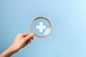 Hand holding magnifying glass with plus icon for medical and health care concept, Access to welfare...