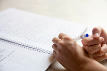 Close up de manos de estudiante escribiendo en una libreta en vacaciones. Zurdos.