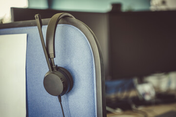 Headphones with a microphone on an office stand in a corporate building.