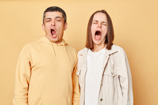 Sleepy Tired Friends Woman And Man Wearing Casual Style Clothing Standing Isolated Over Beige Background Yawning Needs Rest, Drowsing, Having Nap.