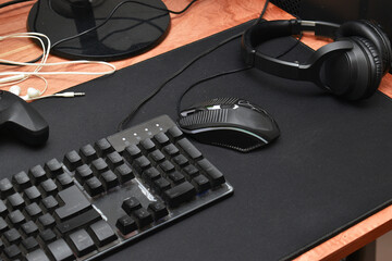 man sitting at a desk using black keyboard mouse and joystick