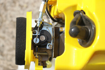 Mechanical components of a petrol brush cutter. Foam filter, starter or spark plug and choke lever in the carburetor of the thermal engine