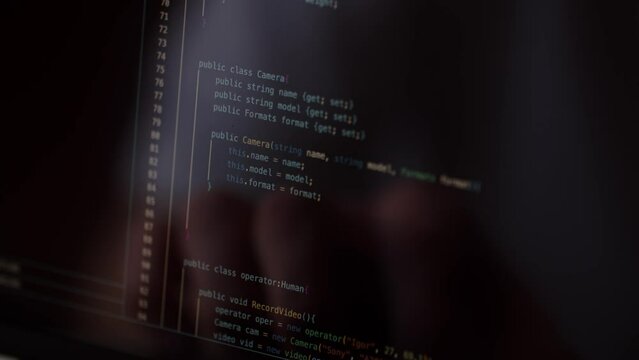 Imitation of a program code. A close-up of a computer screen on which program code is scrolling. A web developer reviews the code of a website to look for bugs. Website development concept.
