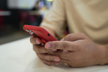 Relaxed young asian man using smart phone  spending time checking news social media.