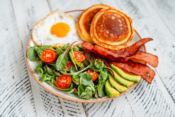 Breakfast Pancakes with Fried Eggs, Bacon and Mixed Salad