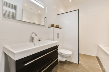 a modern bathroom with black and white fixtures on the vanity, toilet and bathtub in the wall is made of glass