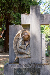 Ein betender Engel neben einem Steinkreuz auf einem alten Friedhof in Roermond