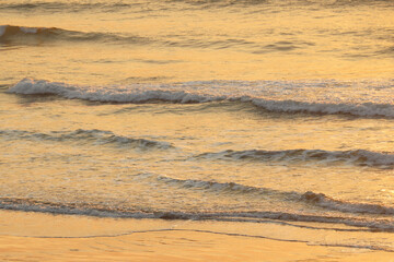 Beautiful sunset light falls on the waves of the sea or ocean.