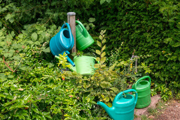 zugewucherte Wasserstelle mit Gießkannen auf einem Friedhof in Düsseldorf Kaiserswerth