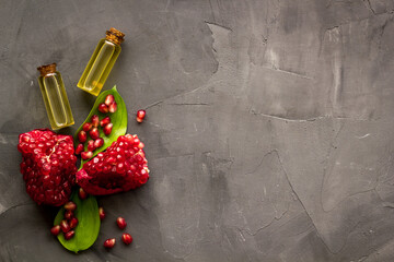 Pomegranate fruit and leaves and bottle of pomegranate seed oil