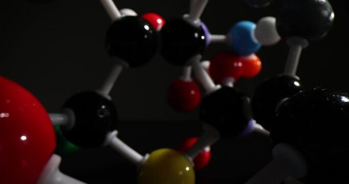 Multi-colored molecular connections on black background in dark premise. Detailed atomic structure concept. Chemistry science and education