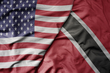 big waving colorful flag of united states of america and national flag of trinidad and tobago .