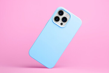 iPhone 15 Pro in blue soft silicone case falls down back view, phone case mockup isolated on pink background