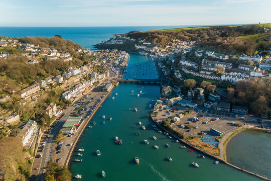 Aerial view of Looe Harbour and moored boats , Looe River and iconic bridge, Cornwall , United Kingdom.