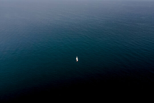 Aerial view of a boat sailing the blue Mediterranean Sea water in summer, Peniscola, Castello, Spain.