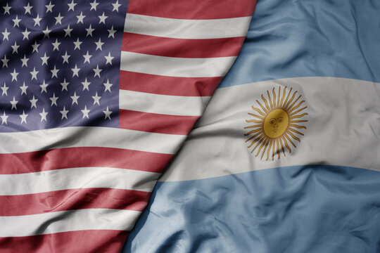 big waving colorful flag of united states of america and national flag of argentina .