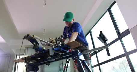 Smiling worker cuts parquet board with electric saw in renovated office slow motion. Builder works with timber in dust cloud low angle shot