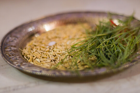 Paddy or rice grains and durva grass kept on a plate for ashirvad ritual of hindu puja and other religious occassions like wedding. These elements are used for blessing the bride and groom.