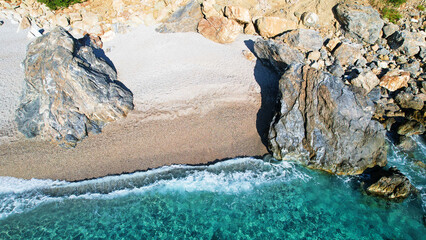 Aerial photo from the seaside Deserted beach among rugged rocks Untouched beach and the majestic coastal stones Prepare to be enchanted by the land and sea in this drone footage