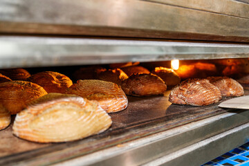Capturing the unseen artistry of a worker in a bakery, as they skillfully slide bread loaves into...