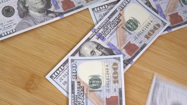 Fake US dollars fall on the table. Counterfeiters check banknotes. Fight against economic crimes. Counting dollars. Demonstration wealth and luxury