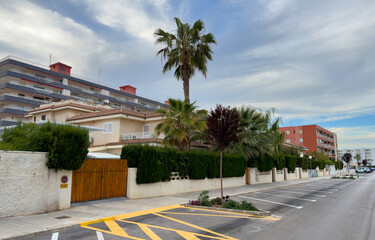 Obraz premium Fence of house at street with pavement road. Suburb house building Exterior. Villa at seaside. Garden in luxury apartments. Fence and facade of house. House Exterior at coast. Residential home