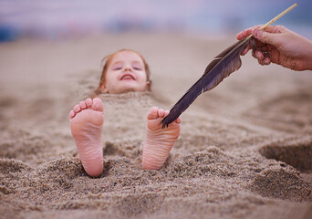 tickling happy baby's feet in a sand. family having fun on sandy beach. summer activity. coastal vacation - obrazy, fototapety, plakaty