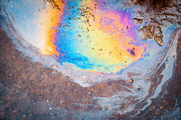 Abstract background from motor oil, gas or petrol spilled on asphalt.