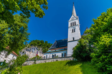 A view from the shoreline of Lake Bled towards the Church in Bled, Slovenia in summertime