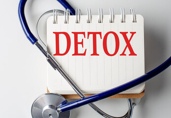 DETOX word on notebook with medical equipment on background