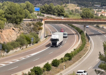 Semi truck with Semi-trailer driving along highway. Goods Delivery by roads. Services and Transport logistics. Highway in Mountains landscape. Road traffic on motorway.