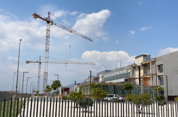 Construction site with tower crane. House and buildings construction. Social Security in Sagunto, Spain. Hotel apartments construction. Housing renovation, real estate. Crane on formwork.