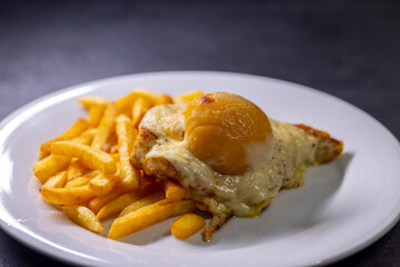 chicken steak baked with cheese and peach served with french fires
