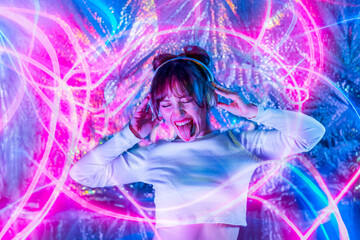 Portrait of emotional woman with closed eyes and tongue out in white clothes and headphones dancing in neon lights. Dj, Music lover. White dress code party. Silent disco. Having fun. Selective focus.