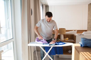 a man ironing his clothes with an iron at home