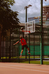 A basketball player plays streetball on a hot day.
