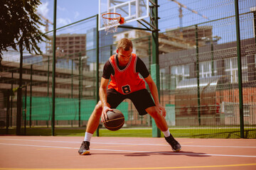 A basketball player plays streetball on a hot day.