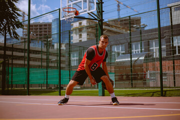 A basketball player plays streetball on a hot day.