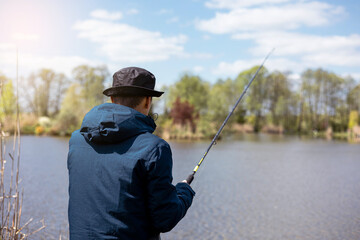 fishing rod on lake water background. Man catching fish by spinning on lakeside