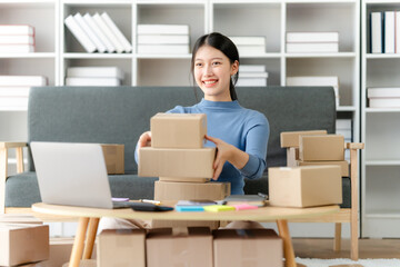 Fashion blogger concept, Young Asian women selling clothes on video streaming.Startup small business SME, using smartphone or tablet taking receive and checking in home office