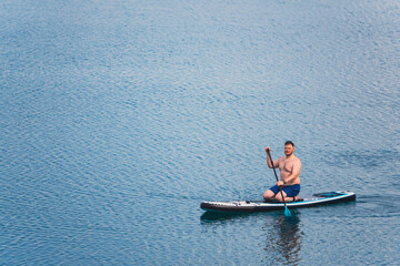 Fototapeta premium man on paddleboard in the middle of the lake