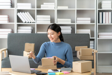 Young business owner woman prepare parcel box and standing check online orders for deliver to customer on tablet, laptop Shopping Online concept.