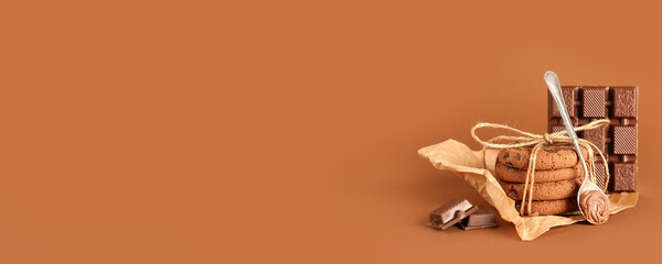 Tasty cookies with chocolate on brown background with space for text