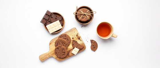 Tasty cookies, chocolate and cup of tea on light background