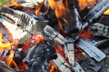 Closeup of burning and flaming hot wood charcoal.